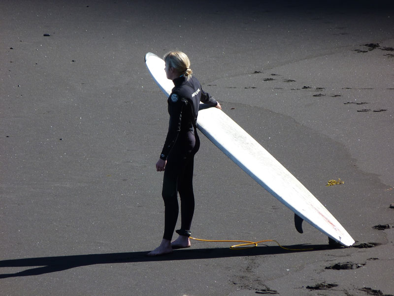 Surfer am Sand mit einem Board in Playa de Tenerife.