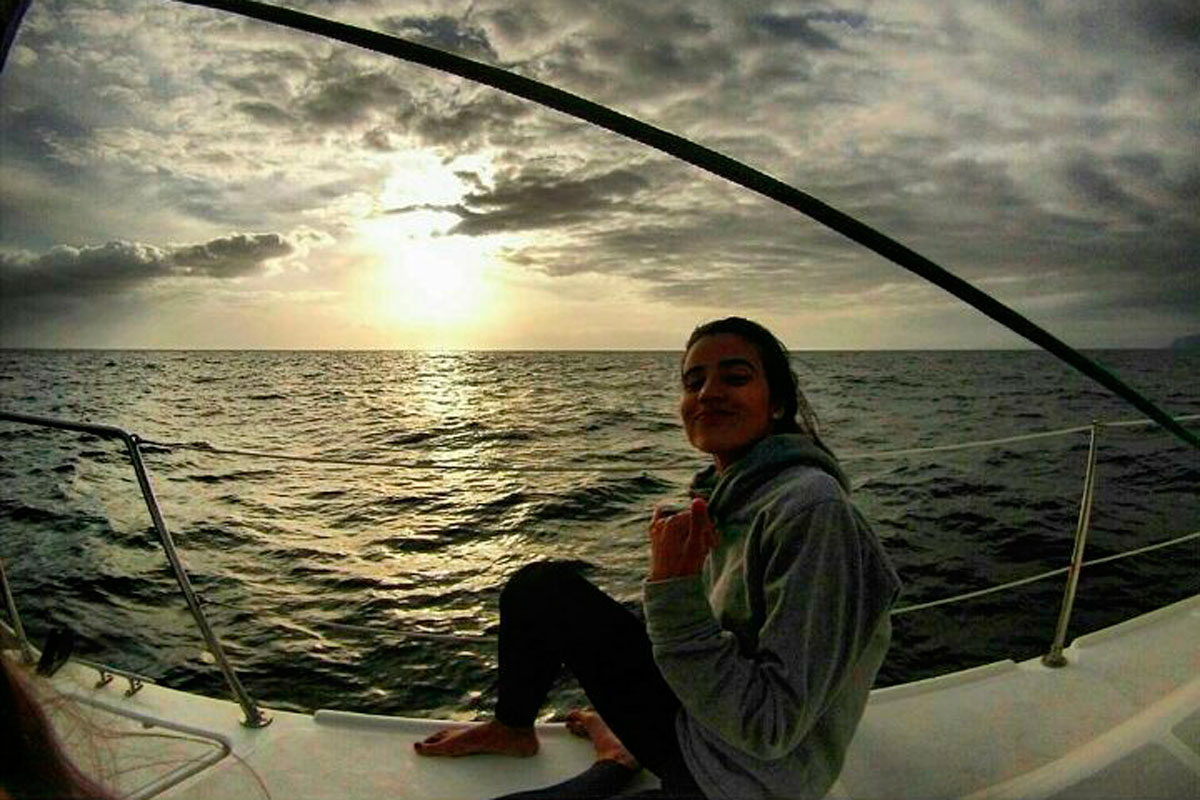 Person, die bei Sonnenuntergang in der Nähe der Küste von Teneriffa auf einem Boot sitzt.
