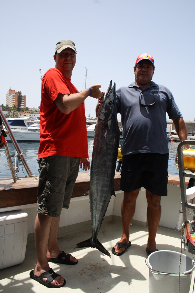 Zwei Personen auf einem Boot mit einem großen Fisch in Los Cristianos, Teneriffa.