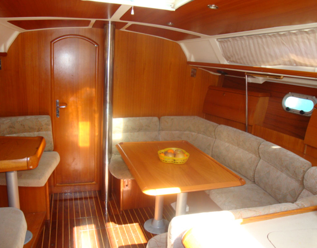 Innenraum einer Yacht mit Holztisch und gepolsterten Sitzen auf Teneriffa.