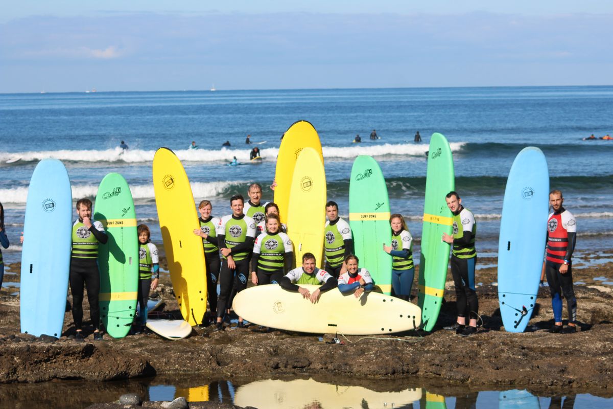 Gruppe von Surfern mit farbigen Brettern am Strand von Teneriffa.