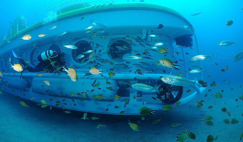 U-Boot, umgeben von Fischen und Tauchern auf dem Meeresboden von Teneriffa.