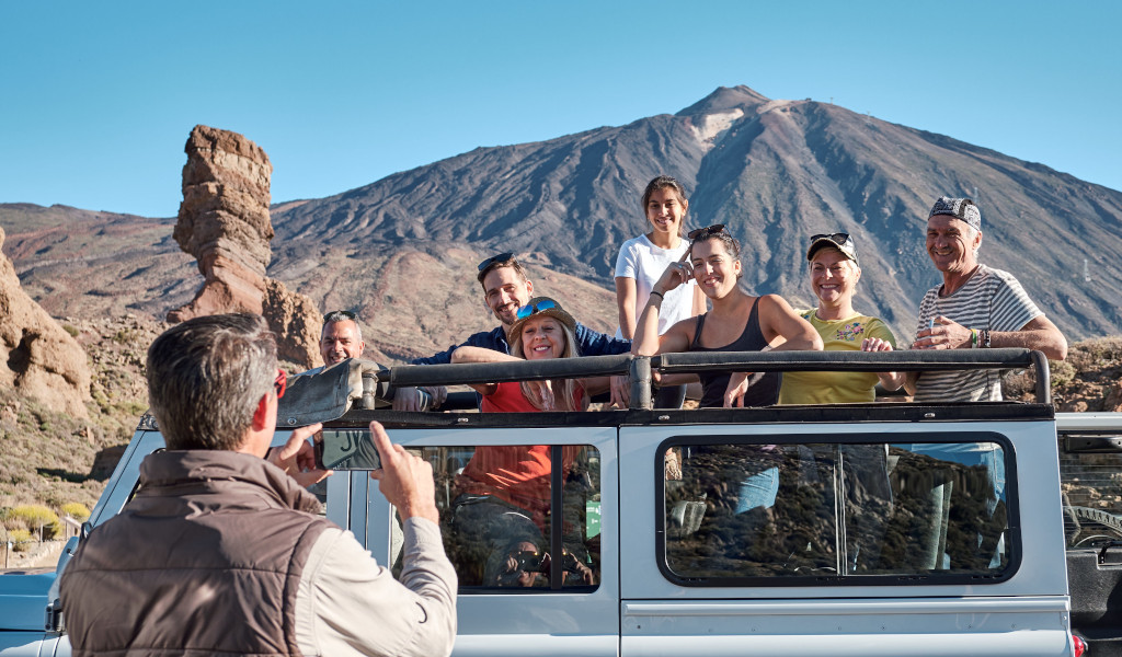 Eine Gruppe von Menschen in einem Jeep vor dem Teide-Berg auf Teneriffa.