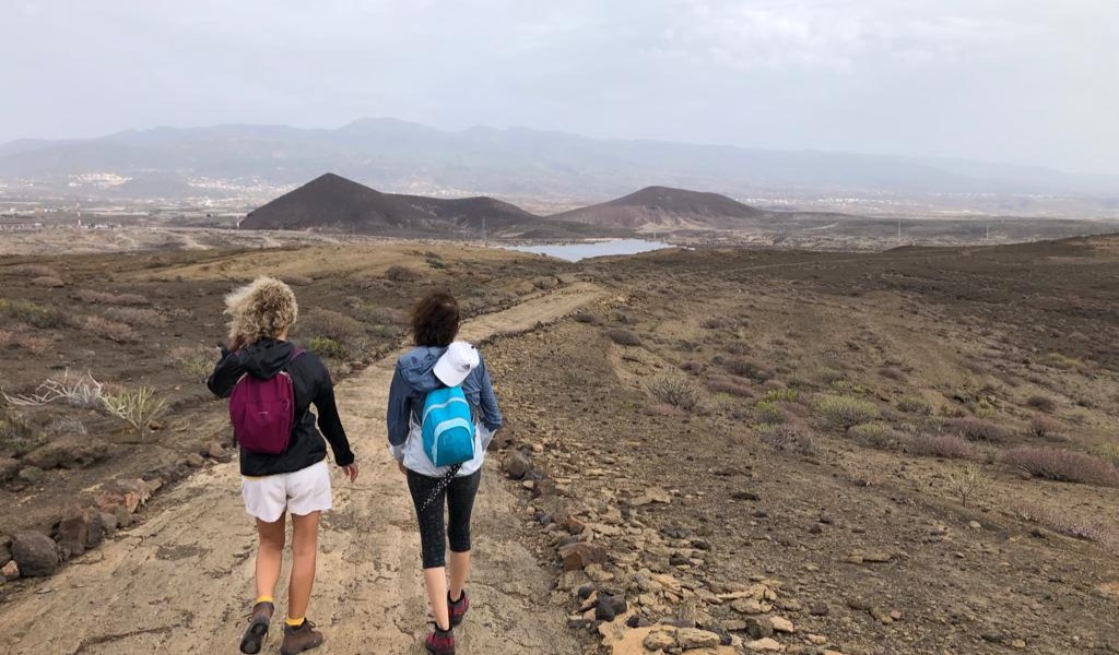 Zwei Personen, die einen Weg in der Landschaft von Teneriffa entlanggehen.