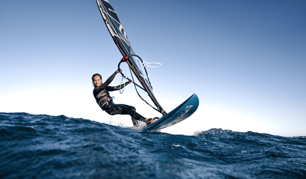 Person Windsurft im Meer bei Teneriffa unter klarem Himmel.