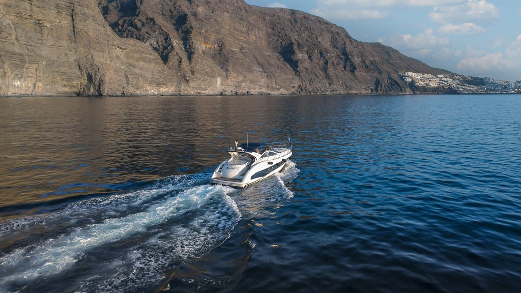 Ein Boot, das in der Nähe der Klippen von Los Gigantes auf Teneriffa segelt.