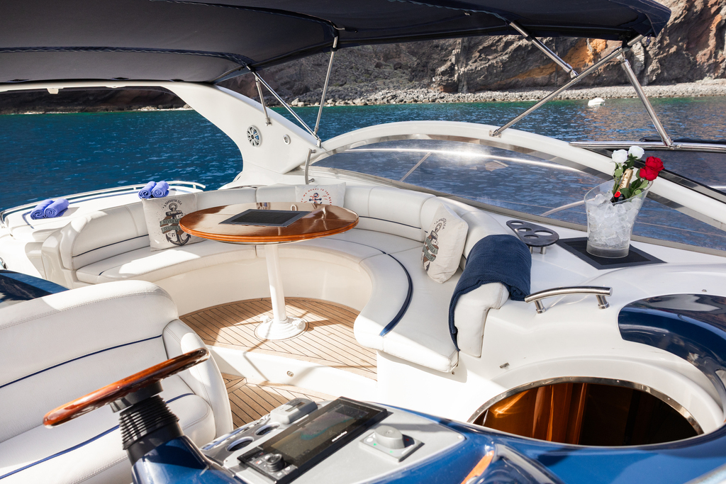 Yacht-Innenraum mit weißen Ledersitzen und einem runden Tisch an der Küste von Teneriffa.