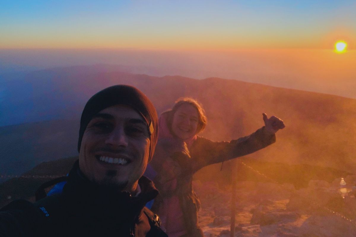 Menschen, die im Morgengrauen auf dem Teideberg, Teneriffa, lächeln, mit der Sonne im Hintergrund.