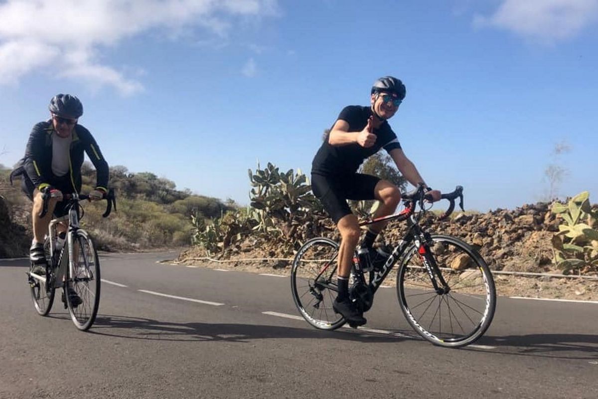 Radfahrer auf der Straße bei Kaktus auf Teneriffa bei klarem Himmel.