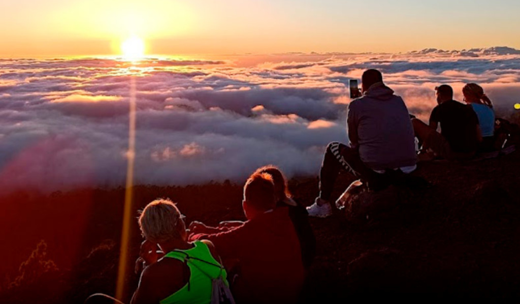 Menschen, die den Sonnenuntergang über den Wolken auf dem Teide auf Teneriffa genießen.