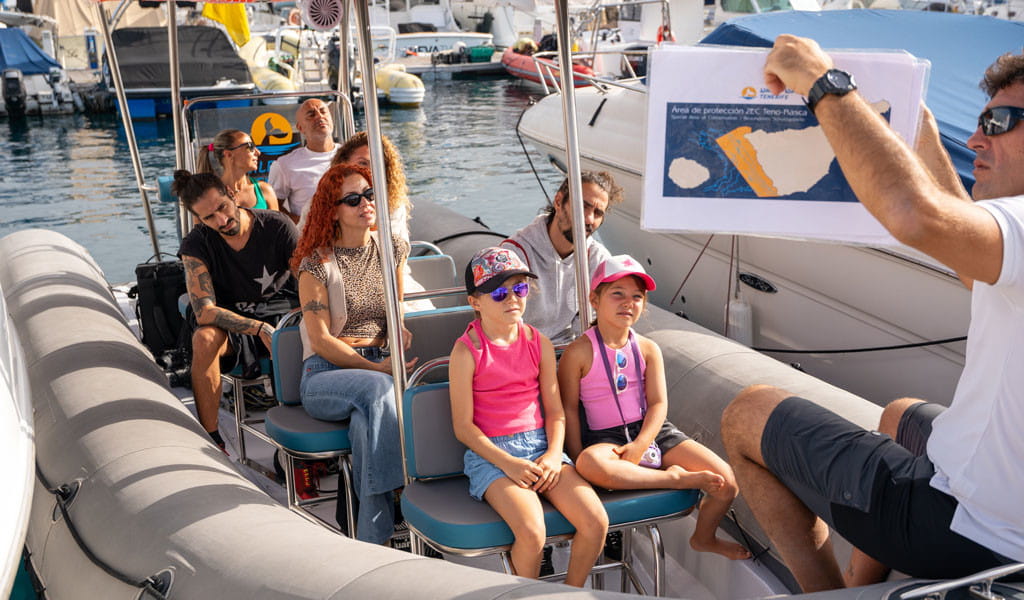 Menschen auf einem Boot auf Teneriffa, Führer zeigt die Karte des TENO-Rasca SAC-Schutzgebiets.