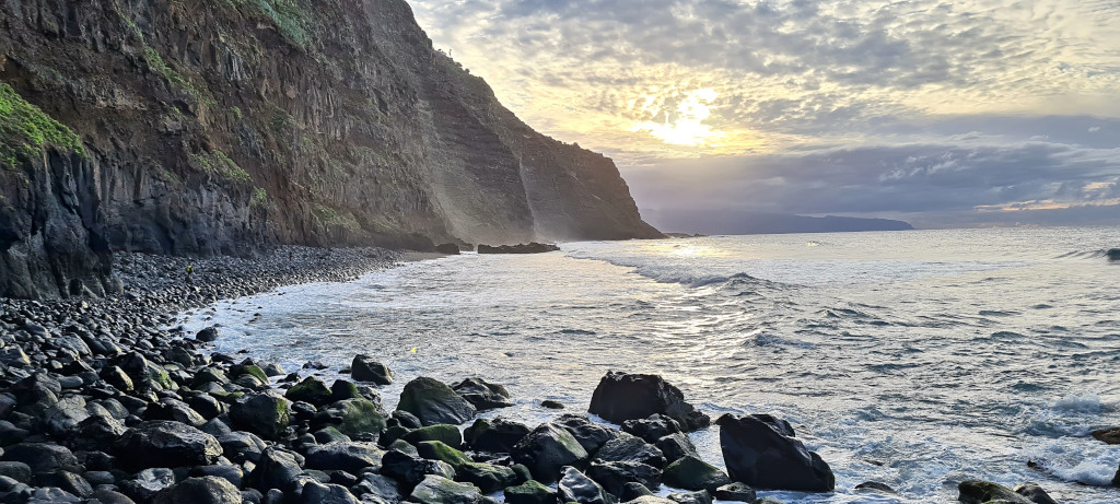 Felsige Küste bei Sonnenuntergang auf Teneriffa mit Klippen und ruhigem Meer.