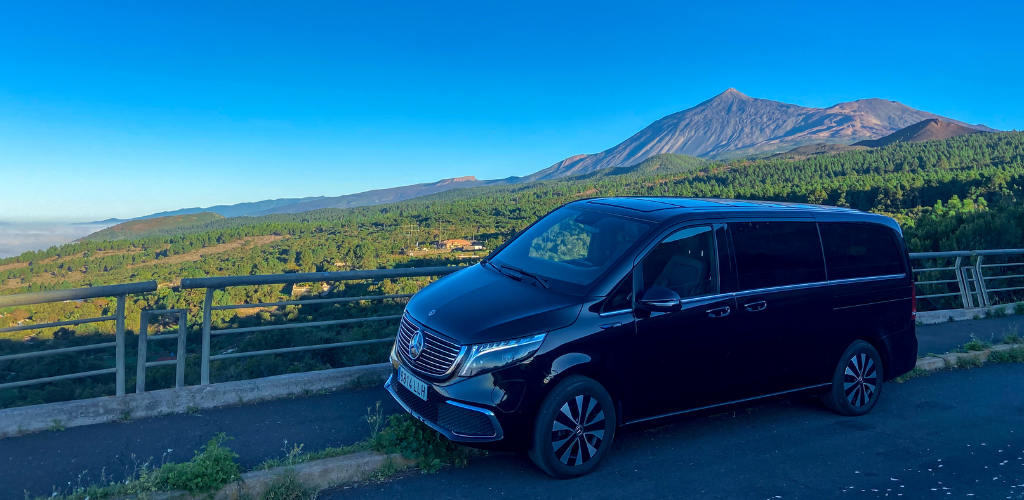 Schwarzes Fahrzeug mit Teide-Hintergrund auf Teneriffa bei klarem Himmel.
