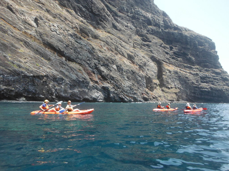Menschen, die vor den Klippen von Los Gigantes auf Teneriffa Kajak fahren.