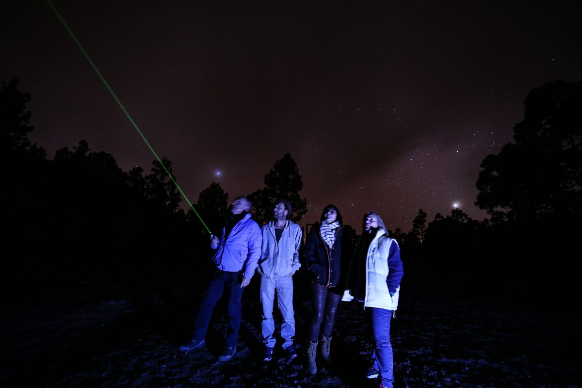 Die Menschen beobachten den sternenklaren Himmel auf Teneriffa, einen grünen Laserpunkt.