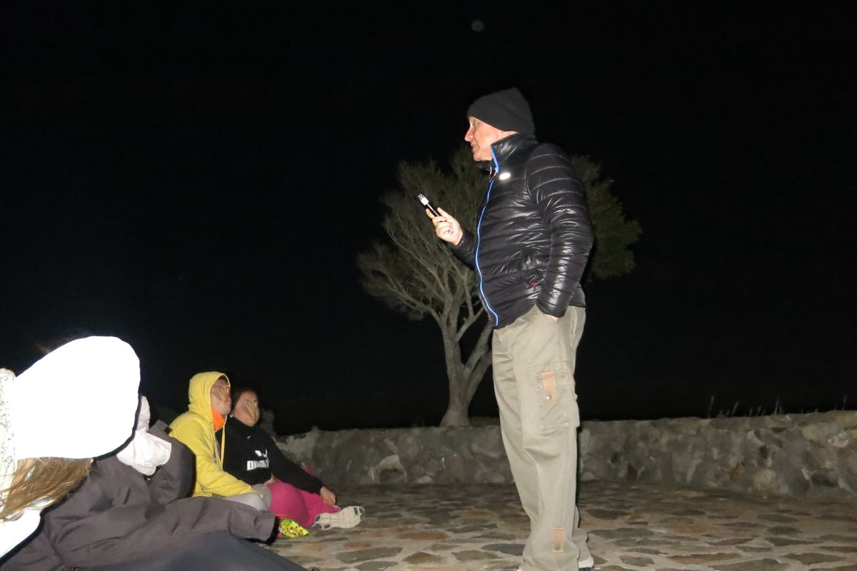Person, die nachts draußen auf Teneriffa spricht, mit einer Gruppe in der Nähe.