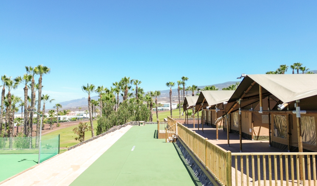 Hütten neben Palmen und Bergen in einem Komplex auf Teneriffa.
