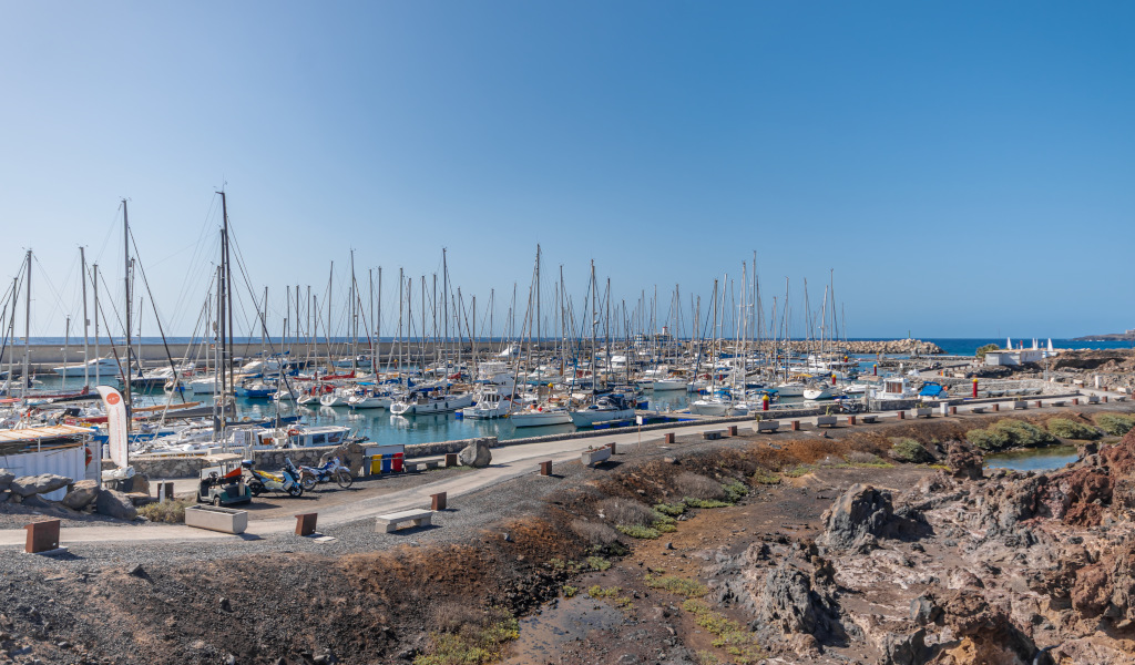 Der Hafen von Los Gigantes auf Teneriffa mit angelegten Booten und blauem Meer.