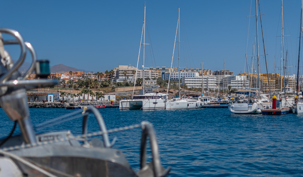 Marina in Costa Adeje, Teneriffa, mit Yachten und Gebäuden im Hintergrund.