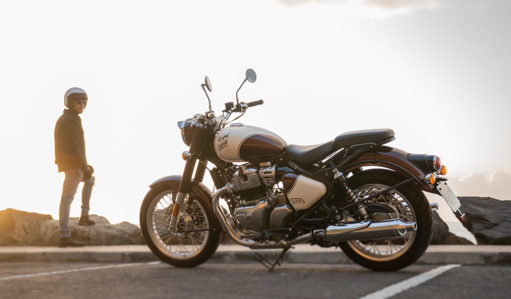 Geparktes Motorrad mit einer Person im Hintergrund stehend bei Sonnenuntergang auf Teneriffa.