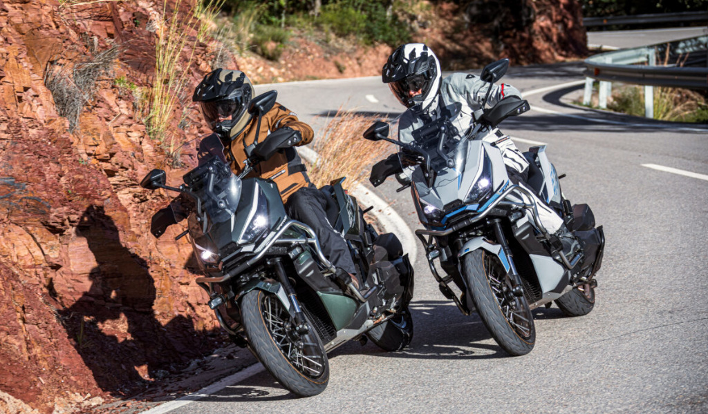Zwei Motorradfahrer auf einer geschwungenen Straße mit felsigem Boden auf Teneriffa.