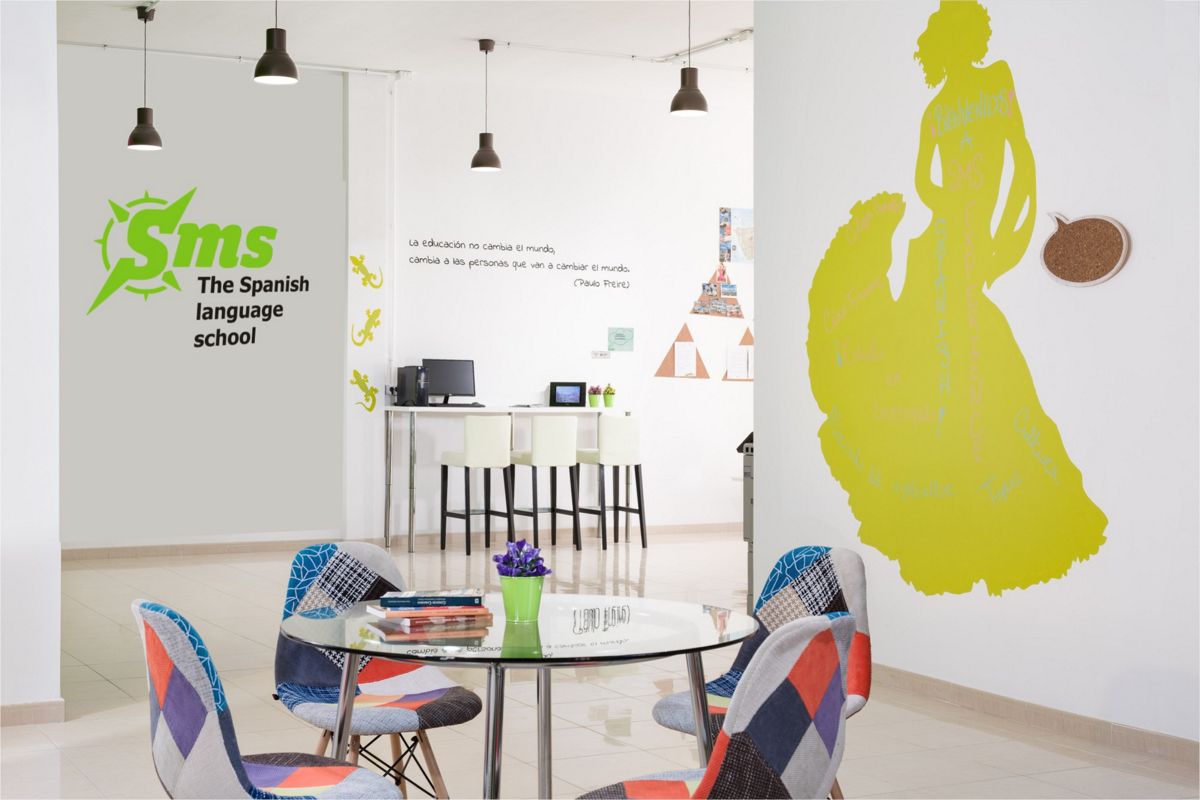 Sprachschulklassenzimmer auf Teneriffa mit bunten Stühlen und einem Motto an der Wand.