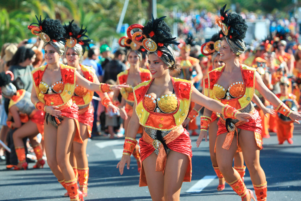 Menschen, die in bunten Kostümen beim Karneval von Teneriffa paradieren.