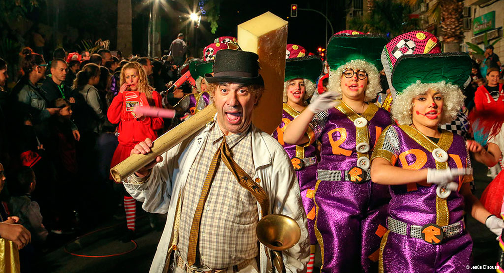 Menschen in bunten Kostümen, die auf einem Karneval in Santa Cruz de Tenerife paradieren.