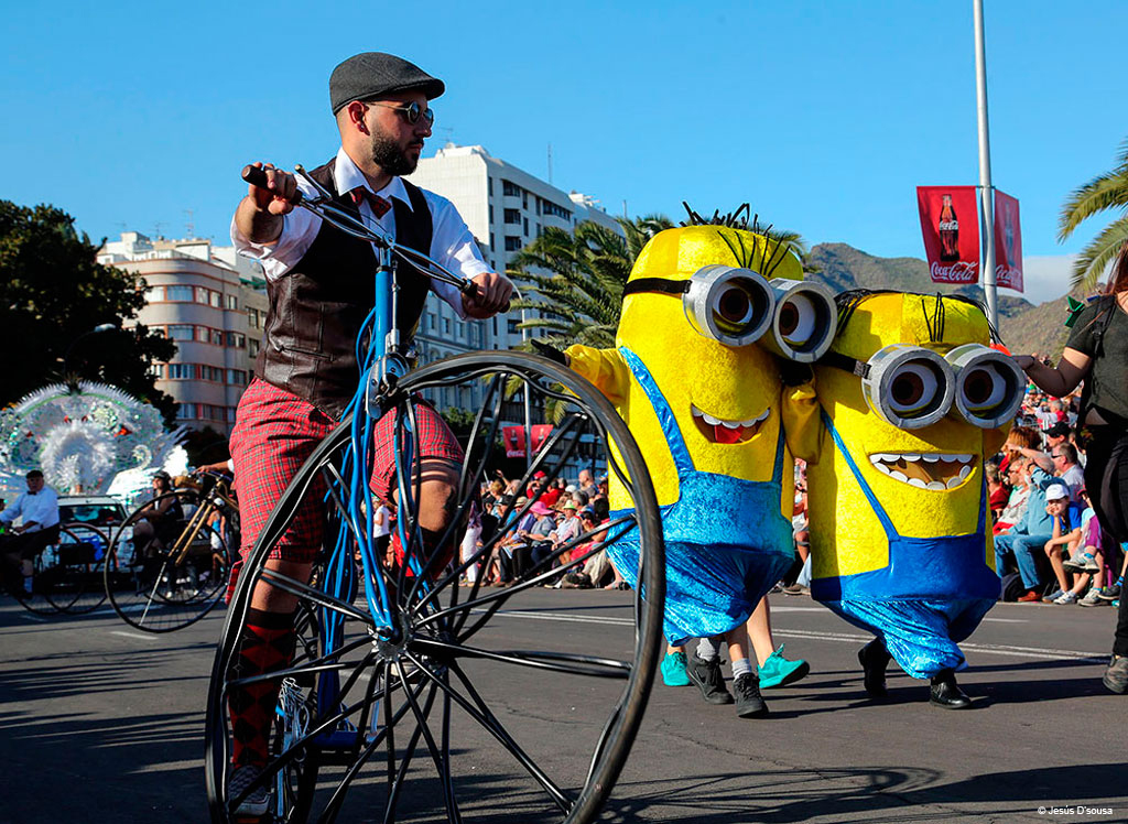 Parade mit Leuten, die als gelbe Figuren verkleidet sind, und Radfahrern auf einem alten Fahrrad auf Teneriffa.