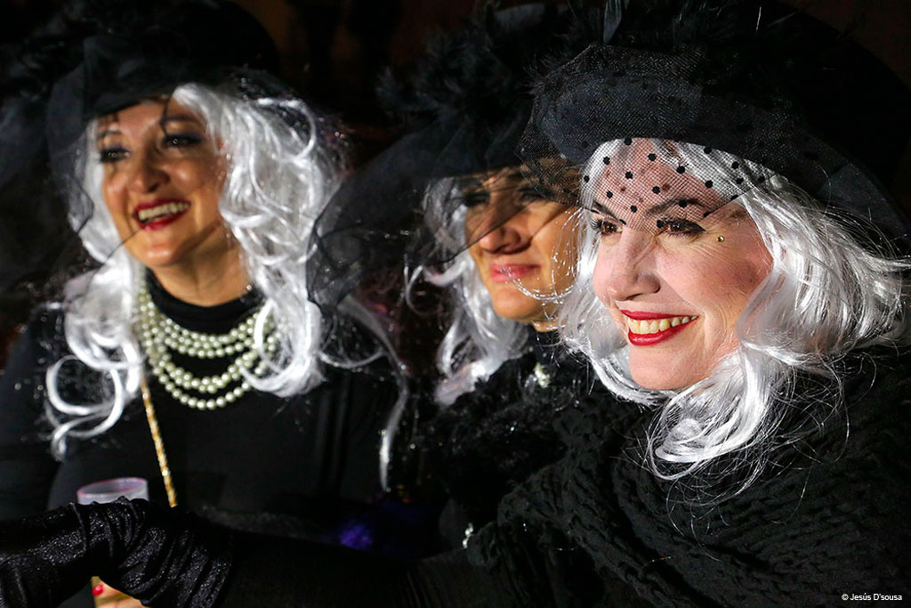 Die Menschen trugen weiße Perücken und schwarze Hüte auf dem Karneval auf Teneriffa.