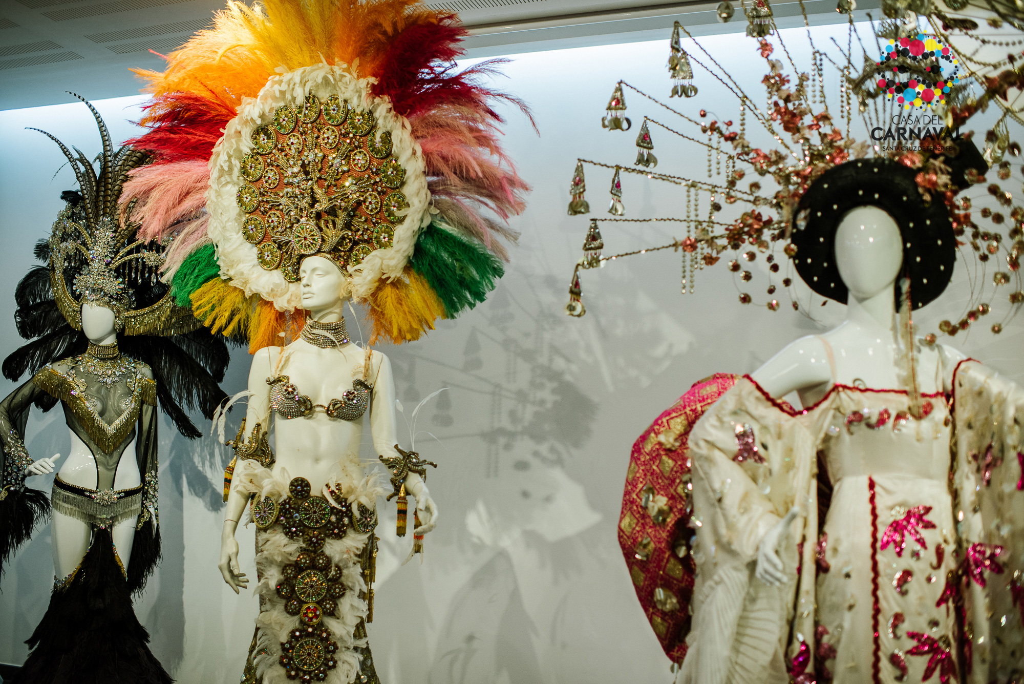 Schaufensterpuppen in Kostümen aus dem Karneval von Santa Cruz de Tenerife, mit farbenfrohen Kopfbedeckungen.