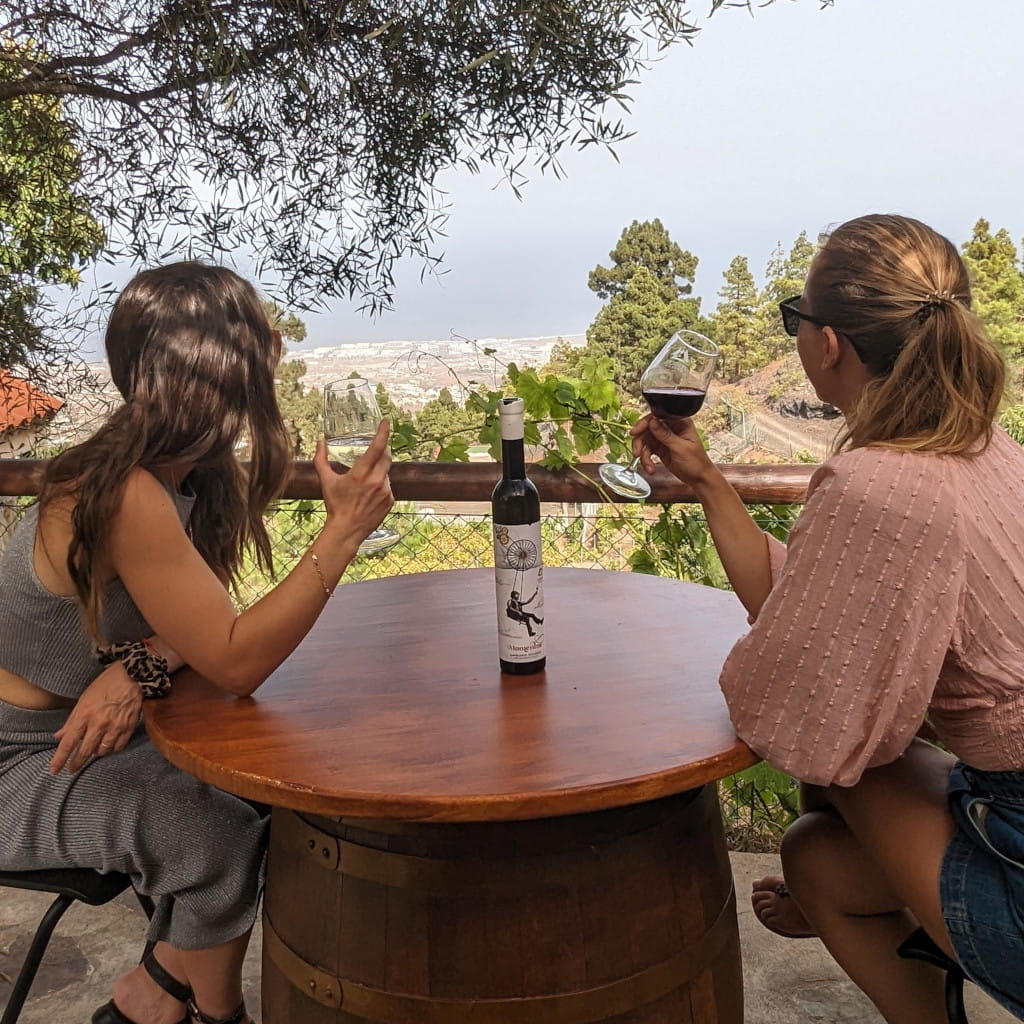 Menschen genießen Wein mit Blick auf La Laguna, Teneriffa. Flasche auf dem Tisch.