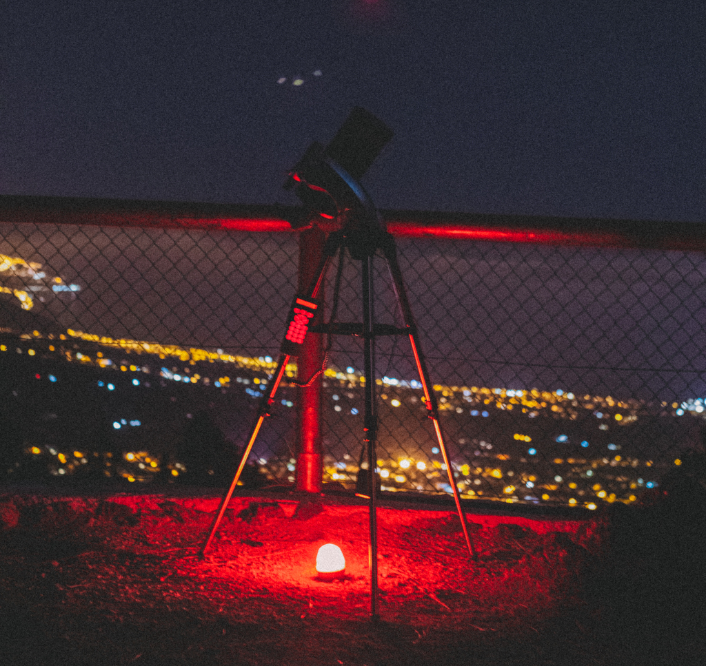 Teleskop im Blickfeld mit städtischen Nachtlichtern auf Teneriffa.