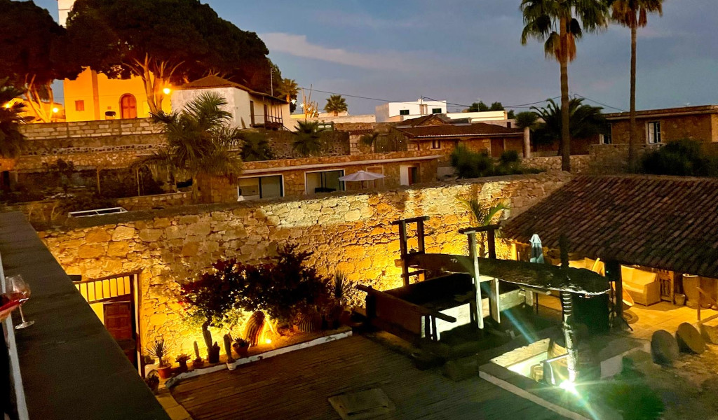 Erleuchteter Innenhof mit Steinmauern und Grünflächen in einem Haus auf Teneriffa.