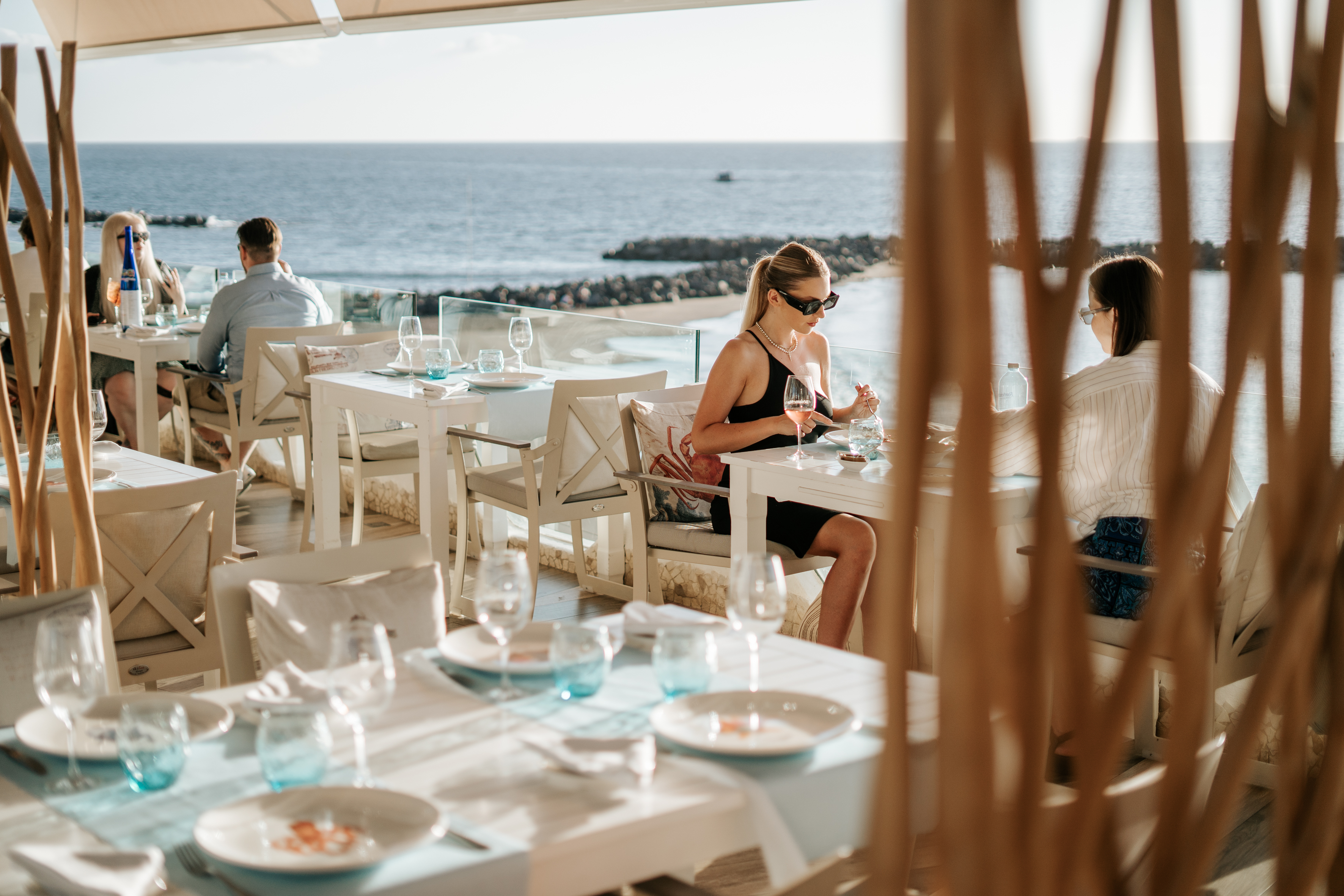 Menschen, die in einem Restaurant mit Blick auf das Meer auf Teneriffa essen.