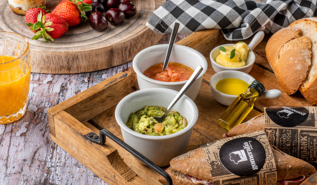 Frühstück mit Obst, Orangensaft, Guacamole, Brot und Olivenöl auf Teneriffa.
