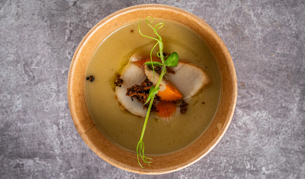 Cremige Suppe mit Gemüse und grünen Sprossen in einer Schüssel auf einem Steintisch auf Teneriffa.