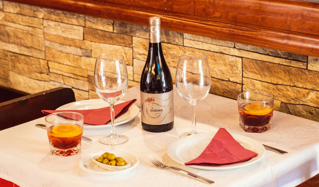Tisch in einem Restaurant auf Teneriffa mit Gläsern, einer Flasche Gondelwein und Gläsern mit Getränken.