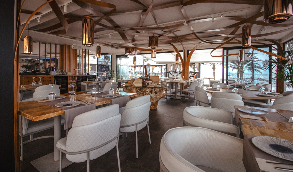Elegantes Restaurant mit auf Teneriffa vorbereiteten Tischen, Außenansicht mit Palmen.
