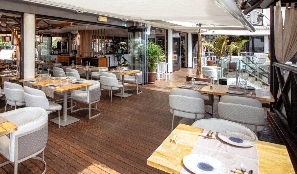 Restaurantterrasse auf Teneriffa mit Tischen und Stühlen, moderne Einrichtung.