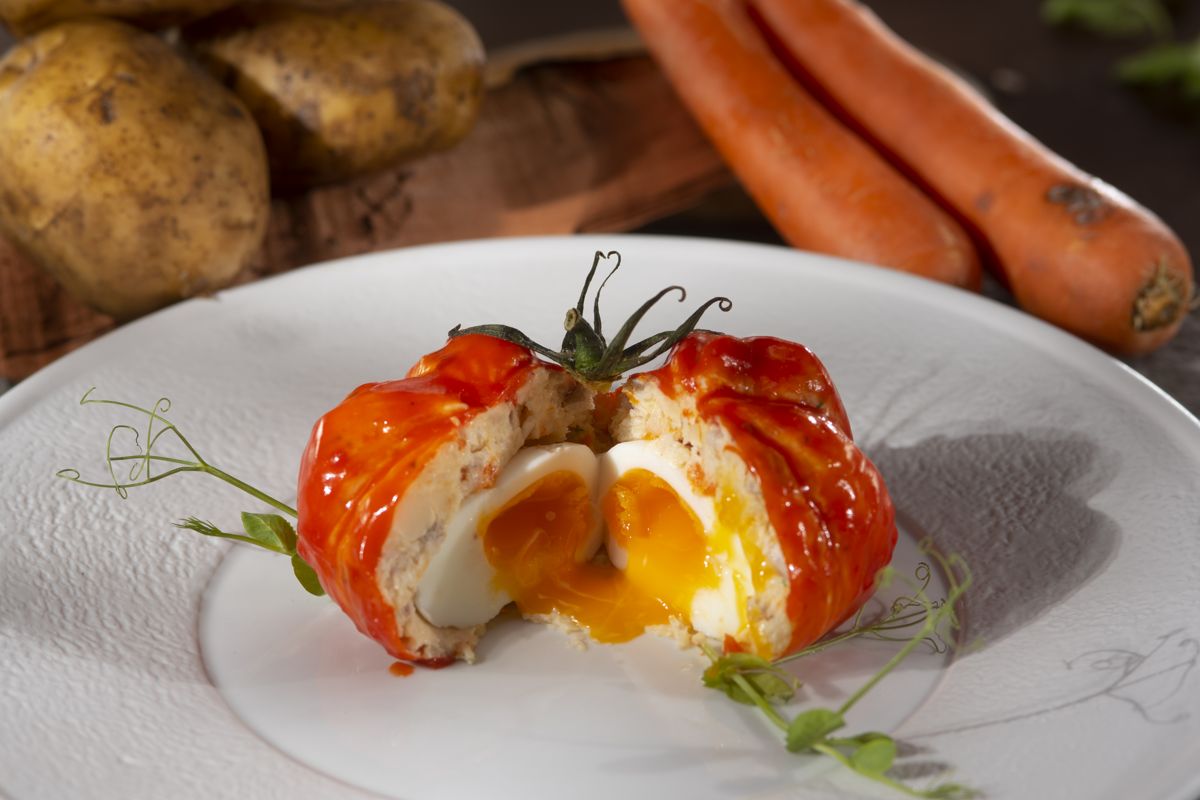 Tomate, gefüllt mit Ei auf einem Teller, umgeben von Karotten und Kartoffeln auf Teneriffa.