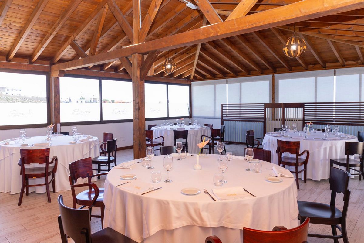 Speisesaal mit runden Tischen und Holzstühlen in einem Restaurant auf Teneriffa.