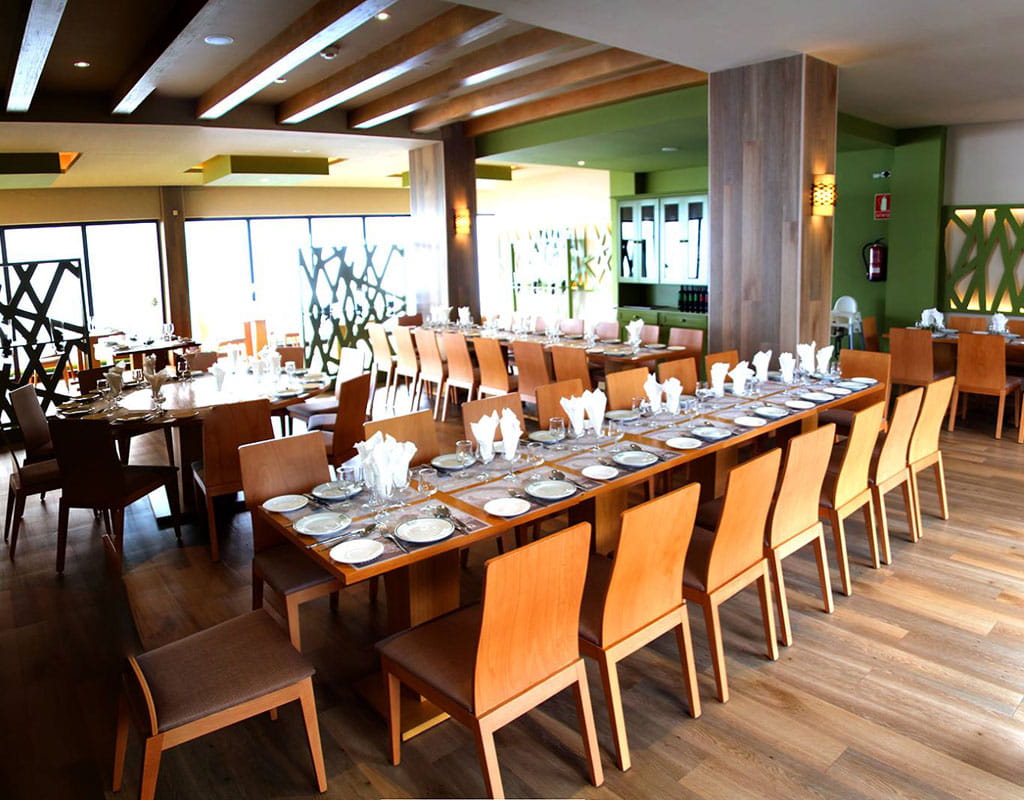 Eleganter Speisesaal mit Holztischen und Stühlen, vorbereitet auf Teneriffa.