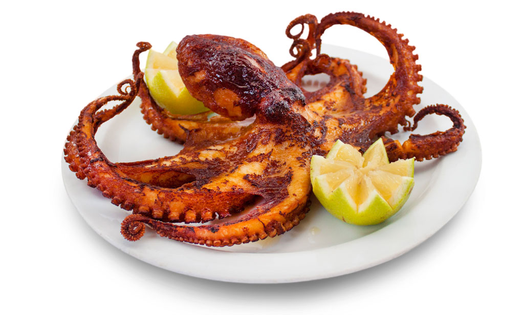 Gegrillter Oktopus, serviert mit Zitronenscheiden auf einem weißen Teller auf Teneriffa.