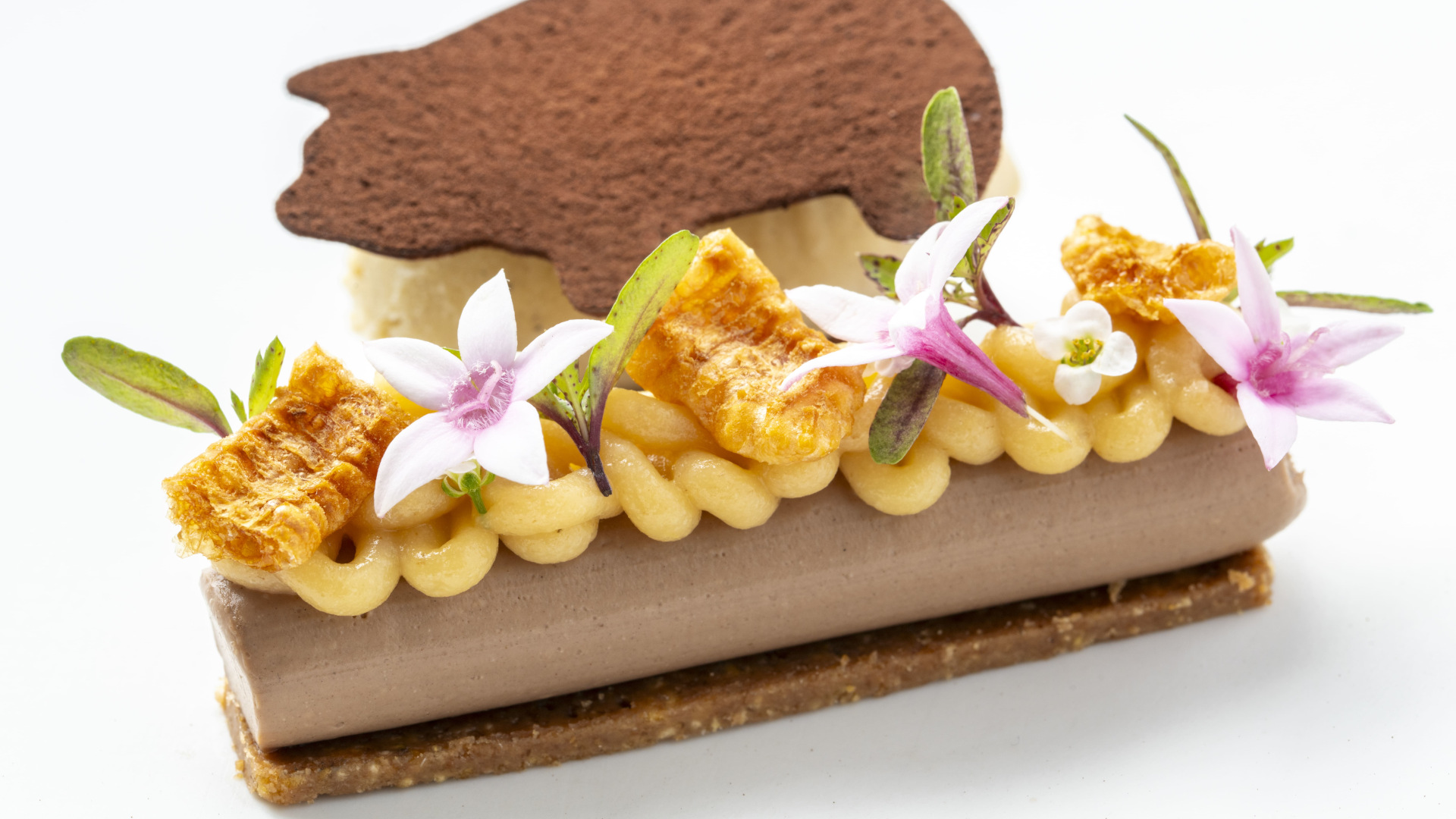 Dessert dekoriert mit Blumen und einer Schokoladenwaffel auf Teneriffa.