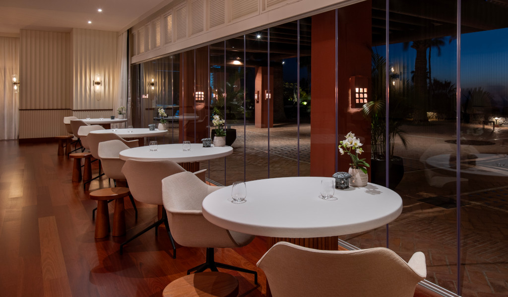 Esstische und Stühle neben großen Fenstern in einem eleganten Restaurant auf Teneriffa.