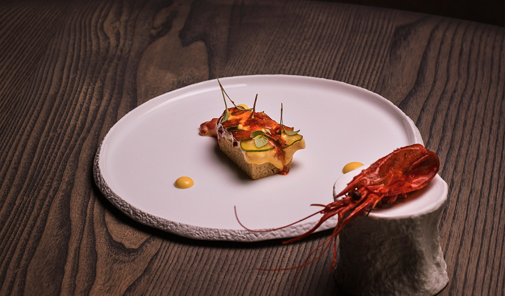 Rote Garnelen und Gourmet-Aperitif auf einem Teller auf einem Holztisch auf Teneriffa.