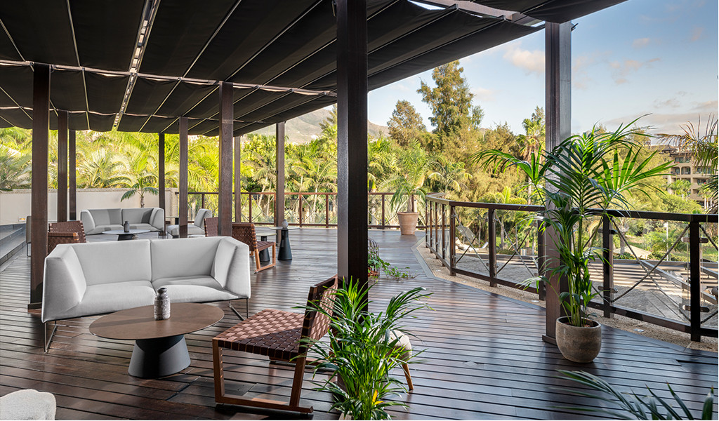 Terrasse mit Gartenmöbeln, umgeben von tropischen Pflanzen auf Teneriffa.