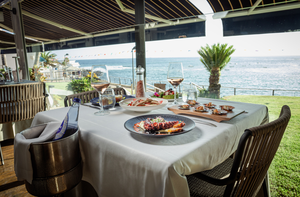 Restauranttisch mit Gourmetgerichten und Meeresblick auf Teneriffa.