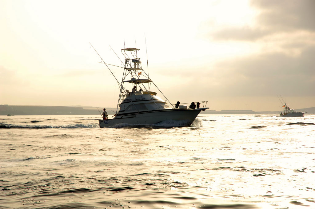 Fischerboot, das bei Sonnenuntergang nahe der Küste von Teneriffa segelt.